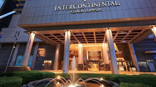 Der Eingang des Intercontinental Kuala Lumpur mit einem Brunnen und gepflegter Bepflanzung.