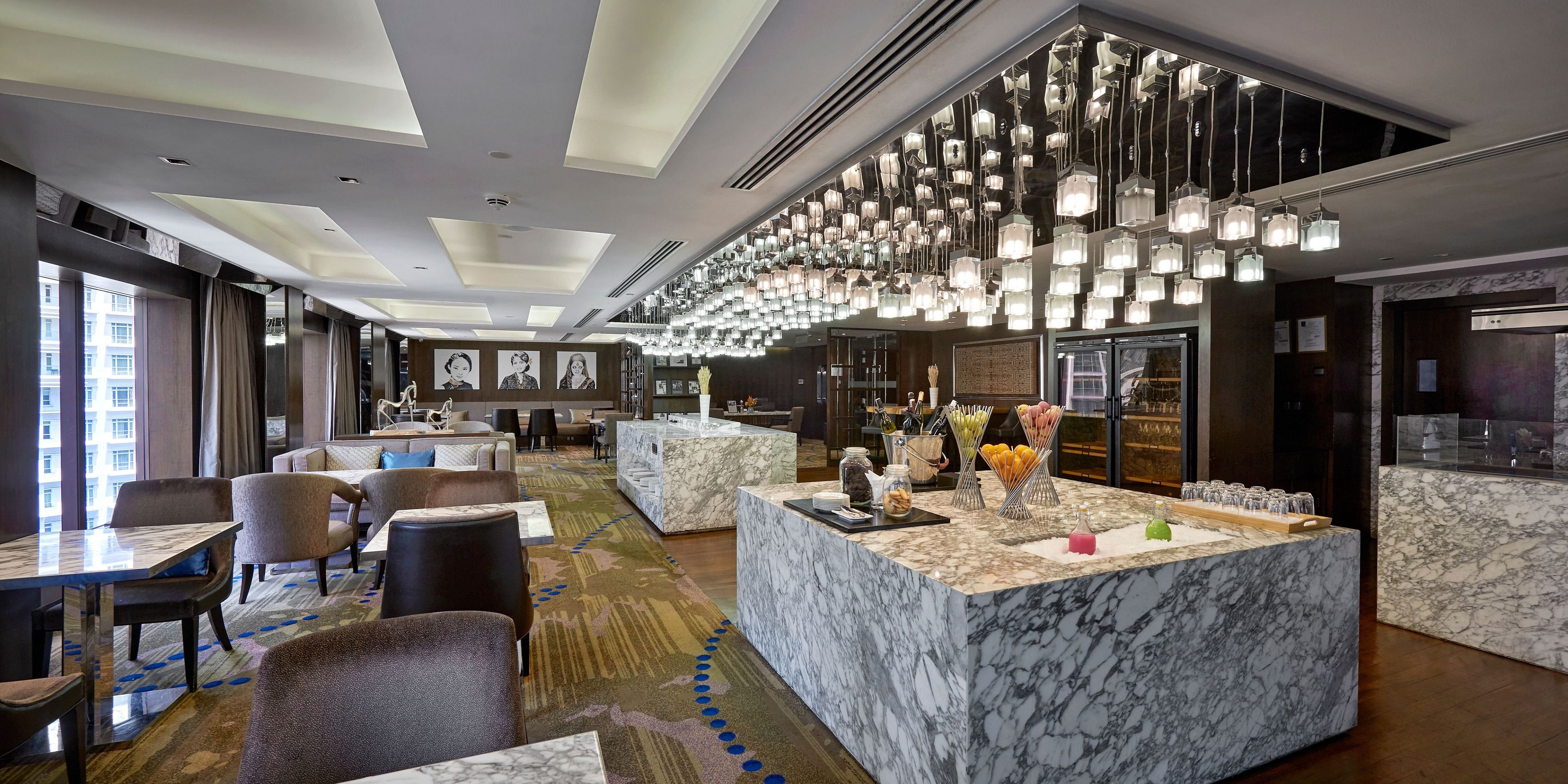 Eine Hotelhalle mit Marmor-Rezeption, Sitzbereichen und einem modernen Kronleuchter.