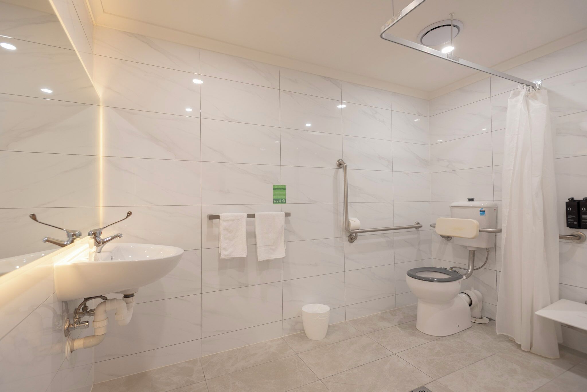 A modern bathroom with a sink, toilet, and shower area.