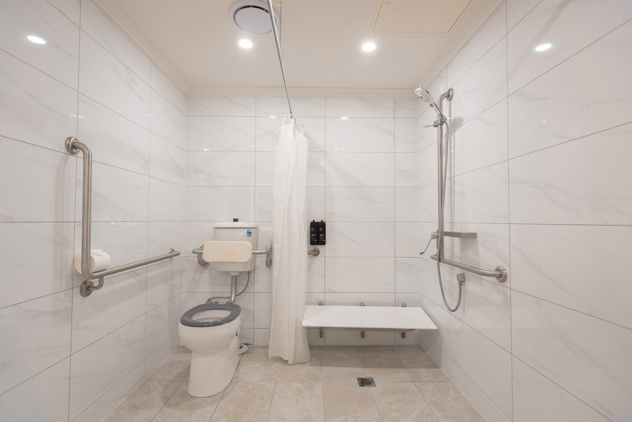 A modern bathroom with a toilet, bidet, and shower.