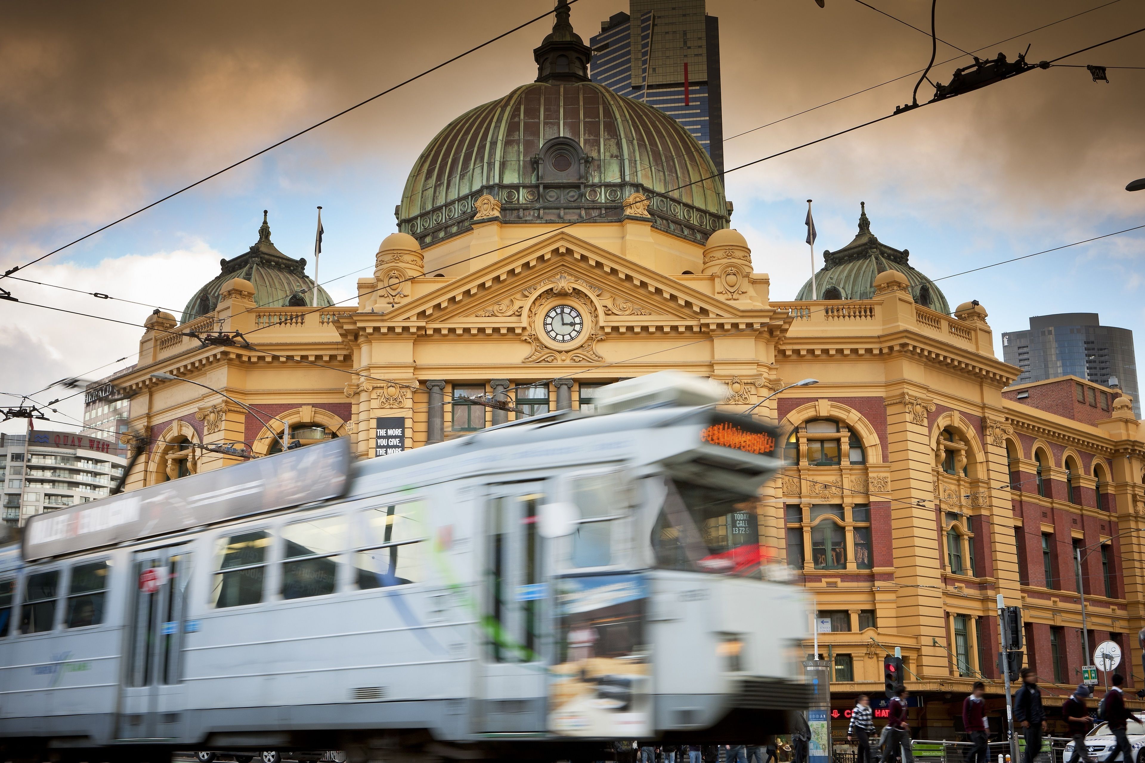 A historic building with a large dome and clock, surrounded by modern high-rise buildings.