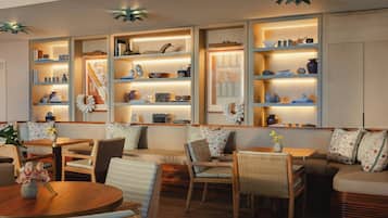 A cozy seating area with tables and chairs, surrounded by shelves with decorative items.