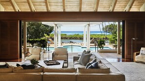 An open-plan living area with a view of a pool and ocean. - Mauna Lani, Auberge Collection (Kamuela)