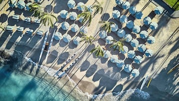 On the beach, white sand, beach cabanas, sun-loungers