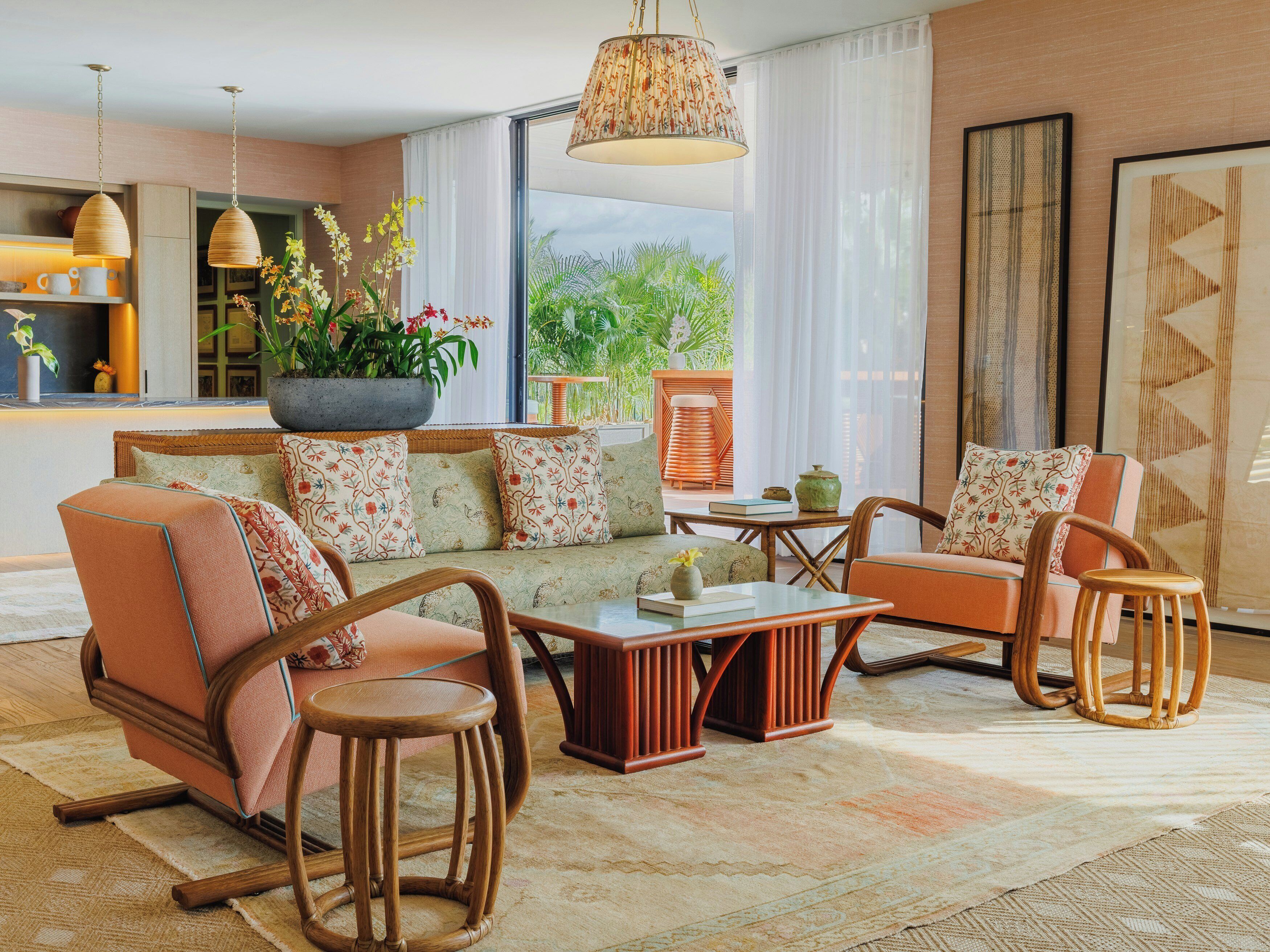 A modern living room with a sofa, chairs, a coffee table, and a large window with a view of greenery.