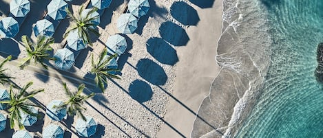 On the beach, white sand, beach cabanas, sun-loungers