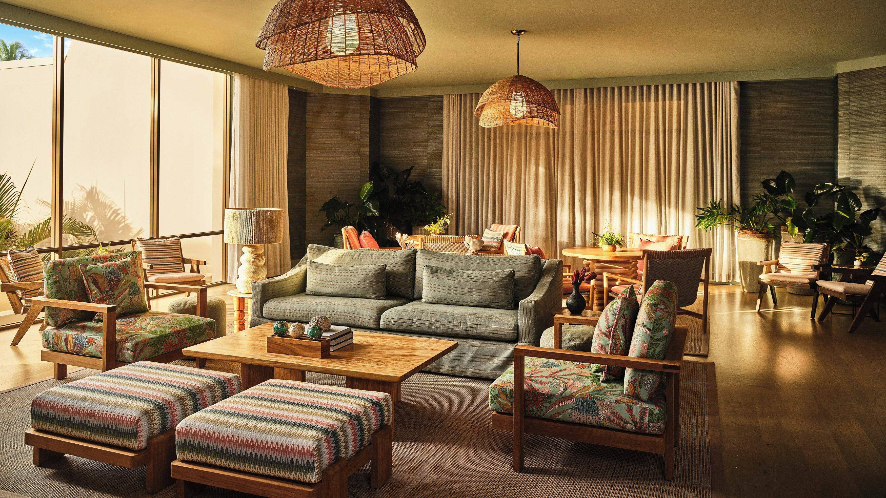 A spacious living room with a sofa, armchairs, a coffee table, and a dining area with a table and chairs.