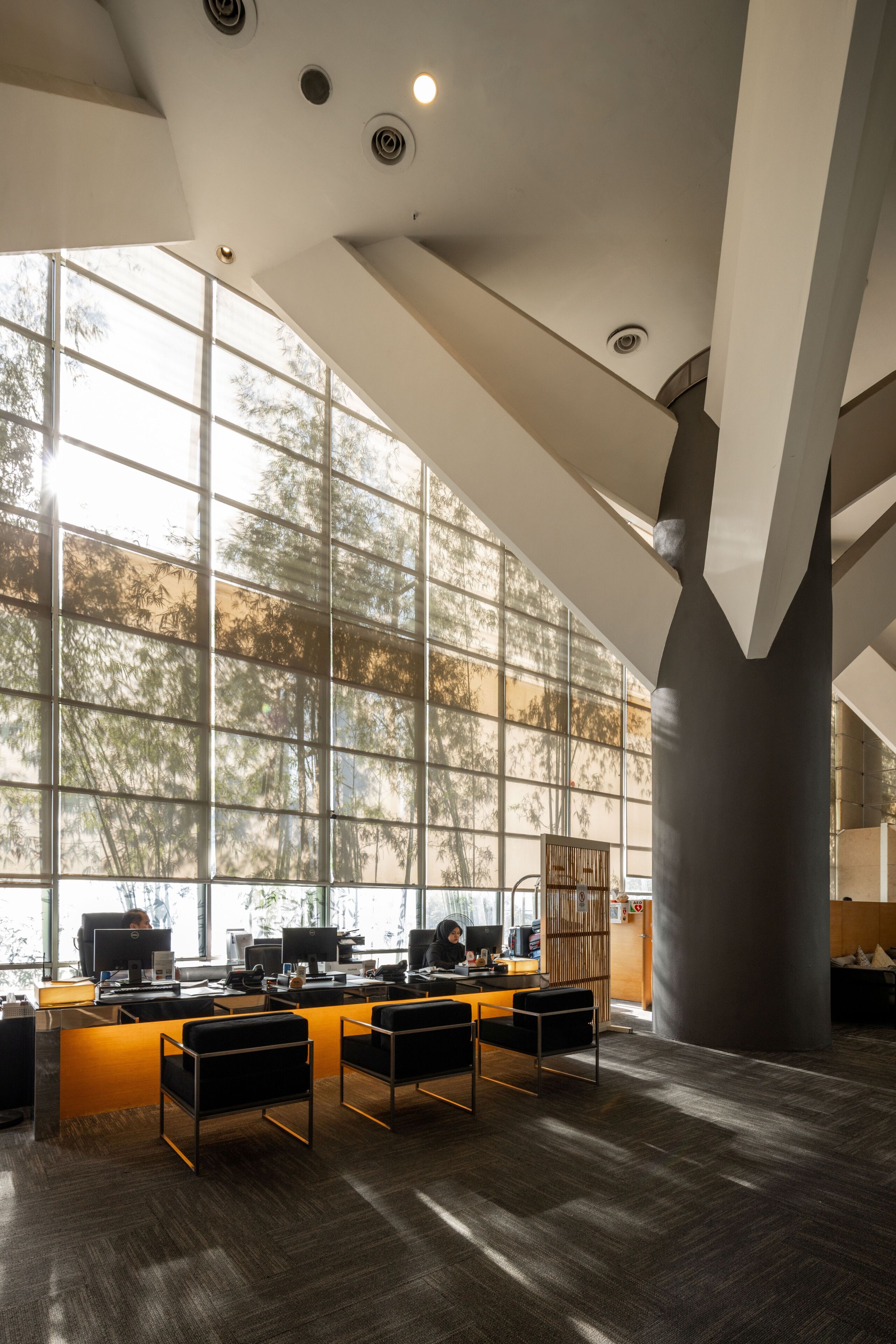 Un bureau spacieux doté de grandes fenêtres, de nombreux postes de travail et d’un design moderne.