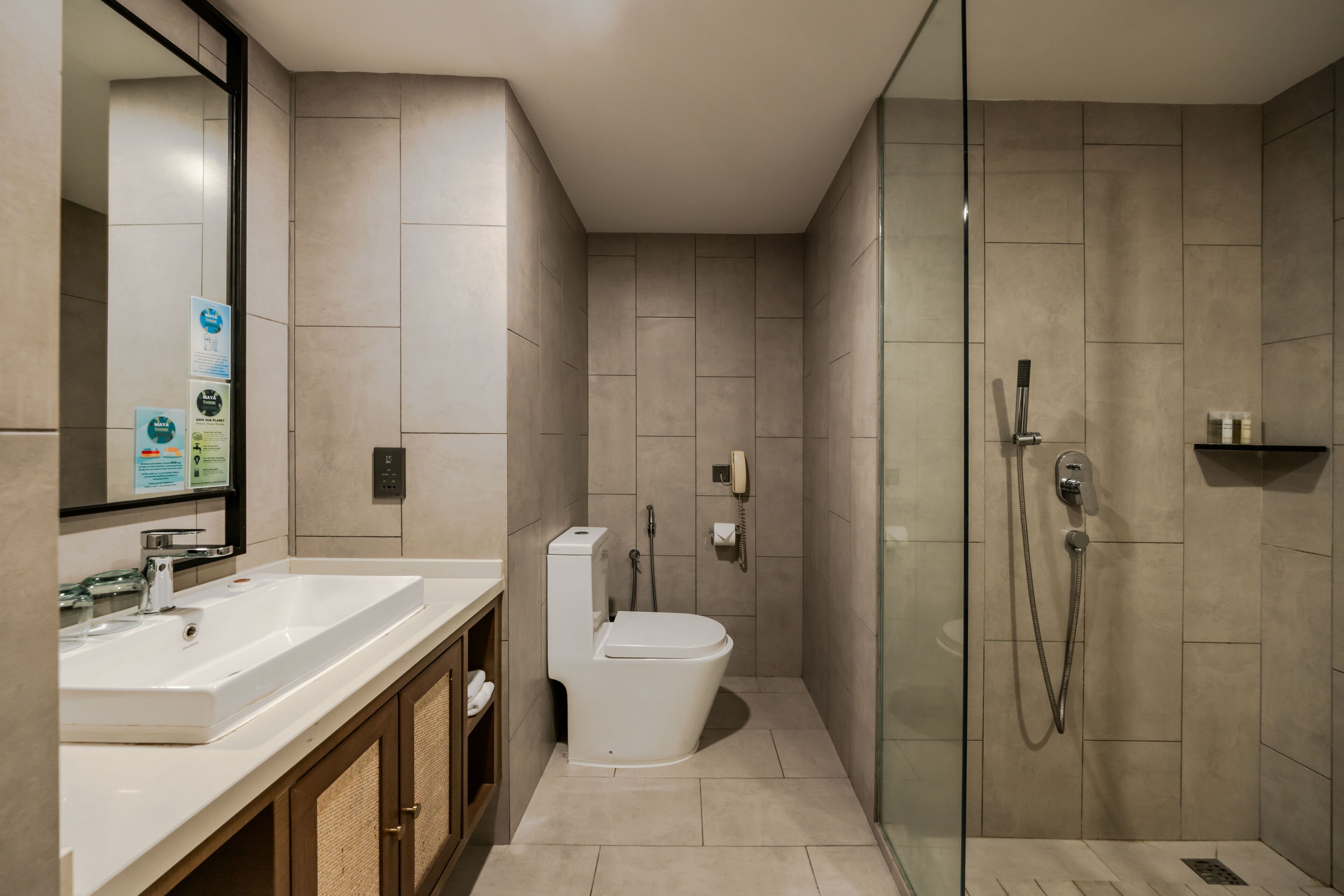 A modern bathroom with a glass-enclosed shower, a white sink, and a toilet.
