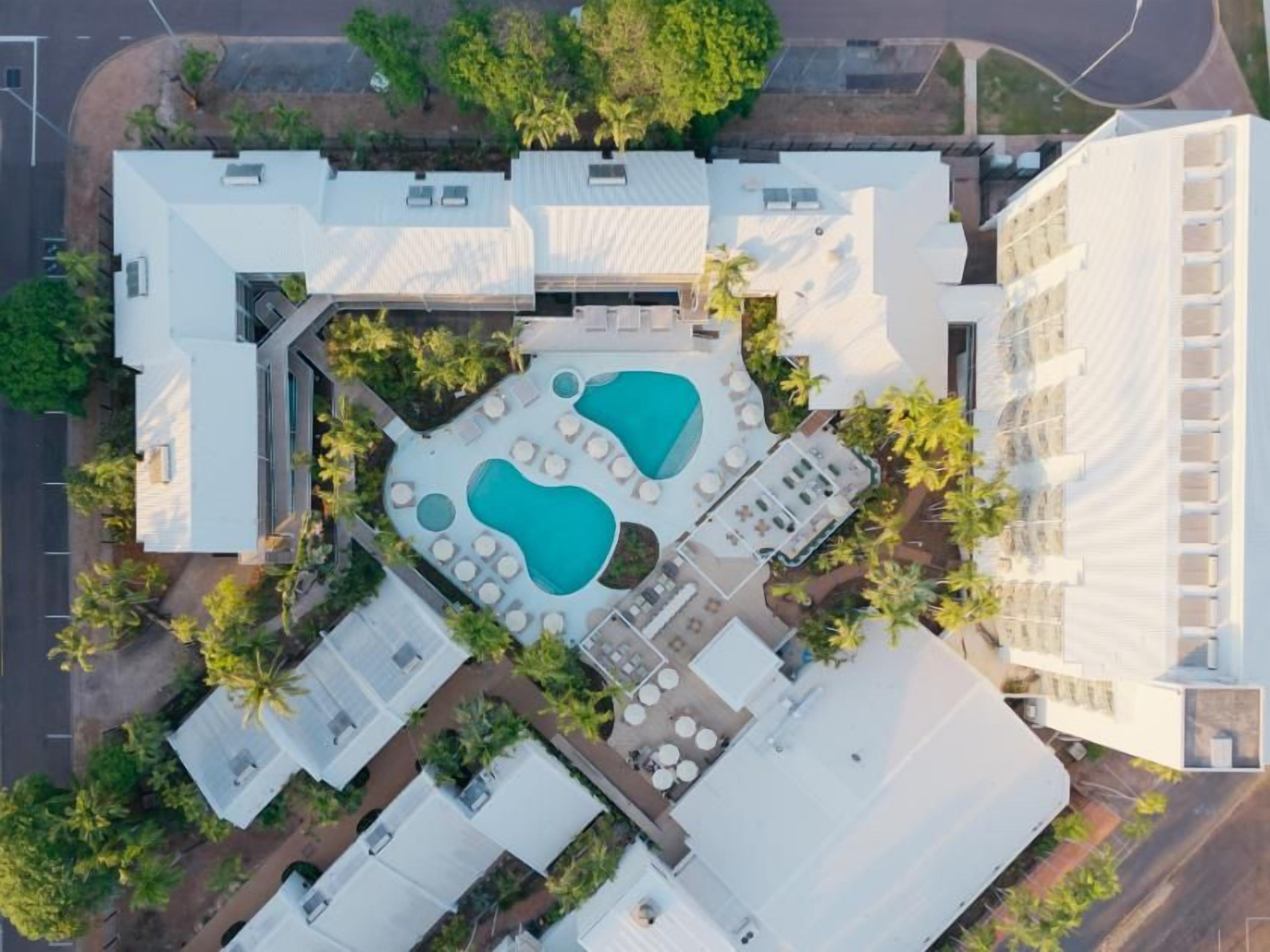 Vue aérienne d’un hôtel doté d’une piscine, d’un espace extérieur aménagé et d’une zone couverte.