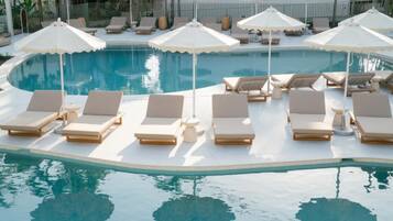 A pool area with lounge chairs and umbrellas.