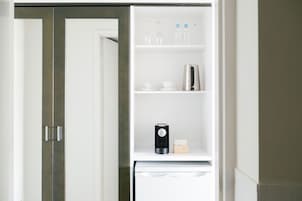 A white refrigerator with a coffee maker and a box of tissues on the door shelf.
