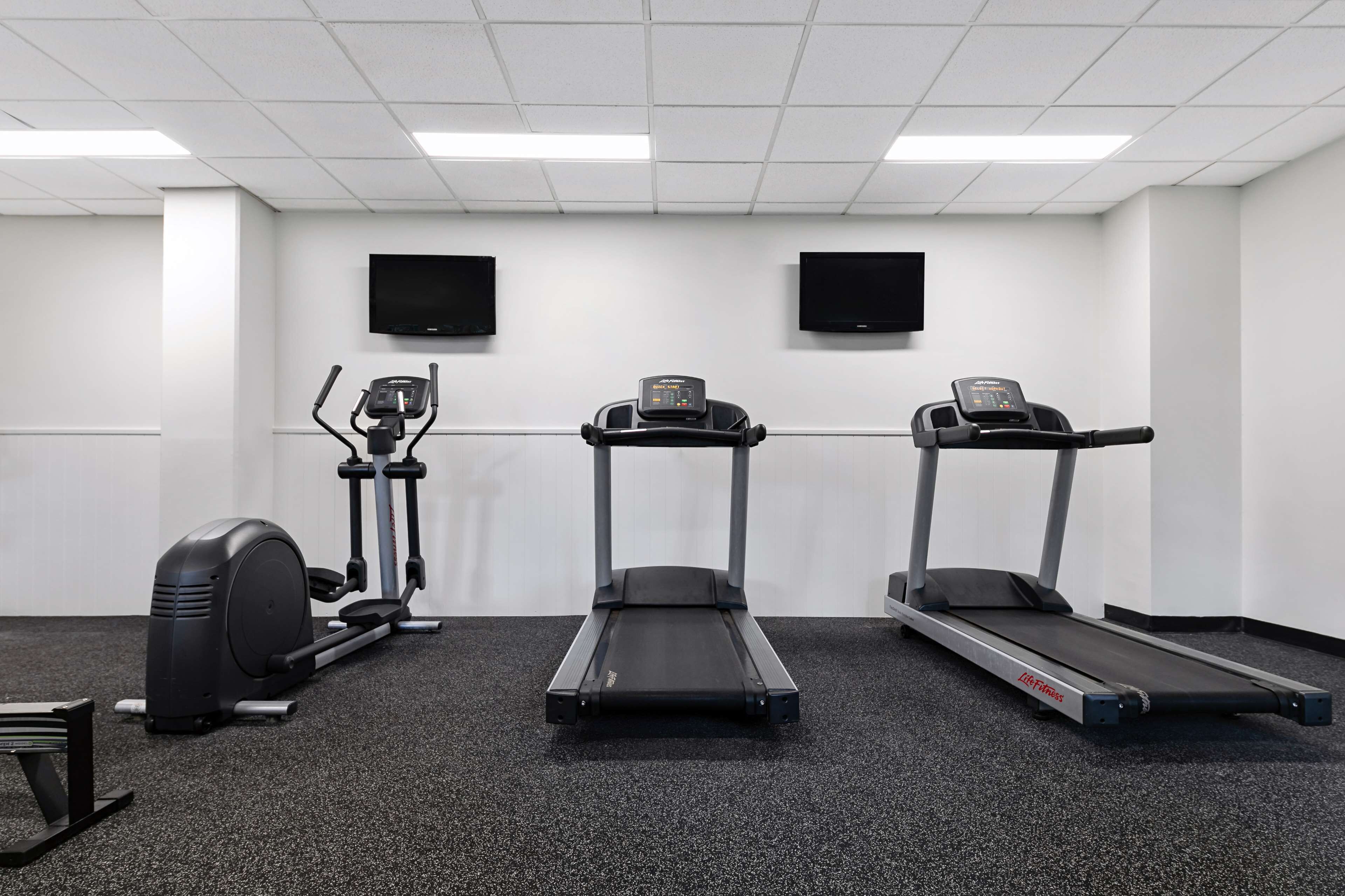 A fitness room with treadmills, an elliptical, and a stationary bike.