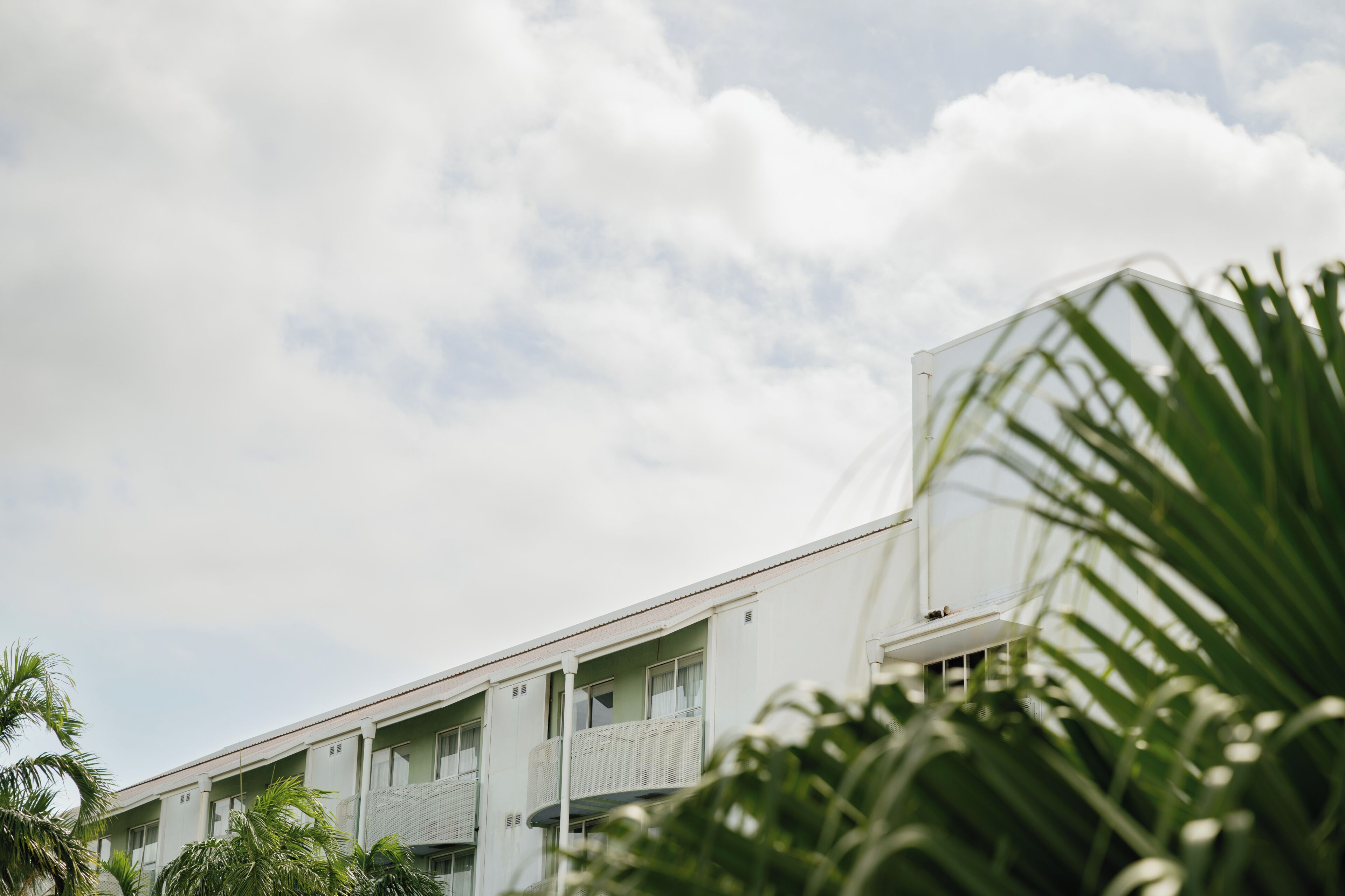 Un immeuble doté de nombreux balcons, d’un toit plat et surplombant un ciel dégagé.
