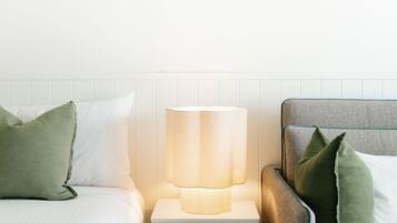 A neatly made bed with pillows, a bedside lamp, and a headboard.