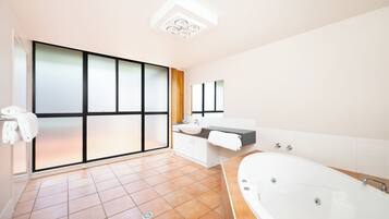 A modern bathroom with a large window, a bathtub, and a vanity with a sink.