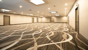 A spacious hotel room with a patterned carpet, recessed lighting, and a door on the right. - SureStay Plus Hotel by Best Western Point Richmond (Richmond)