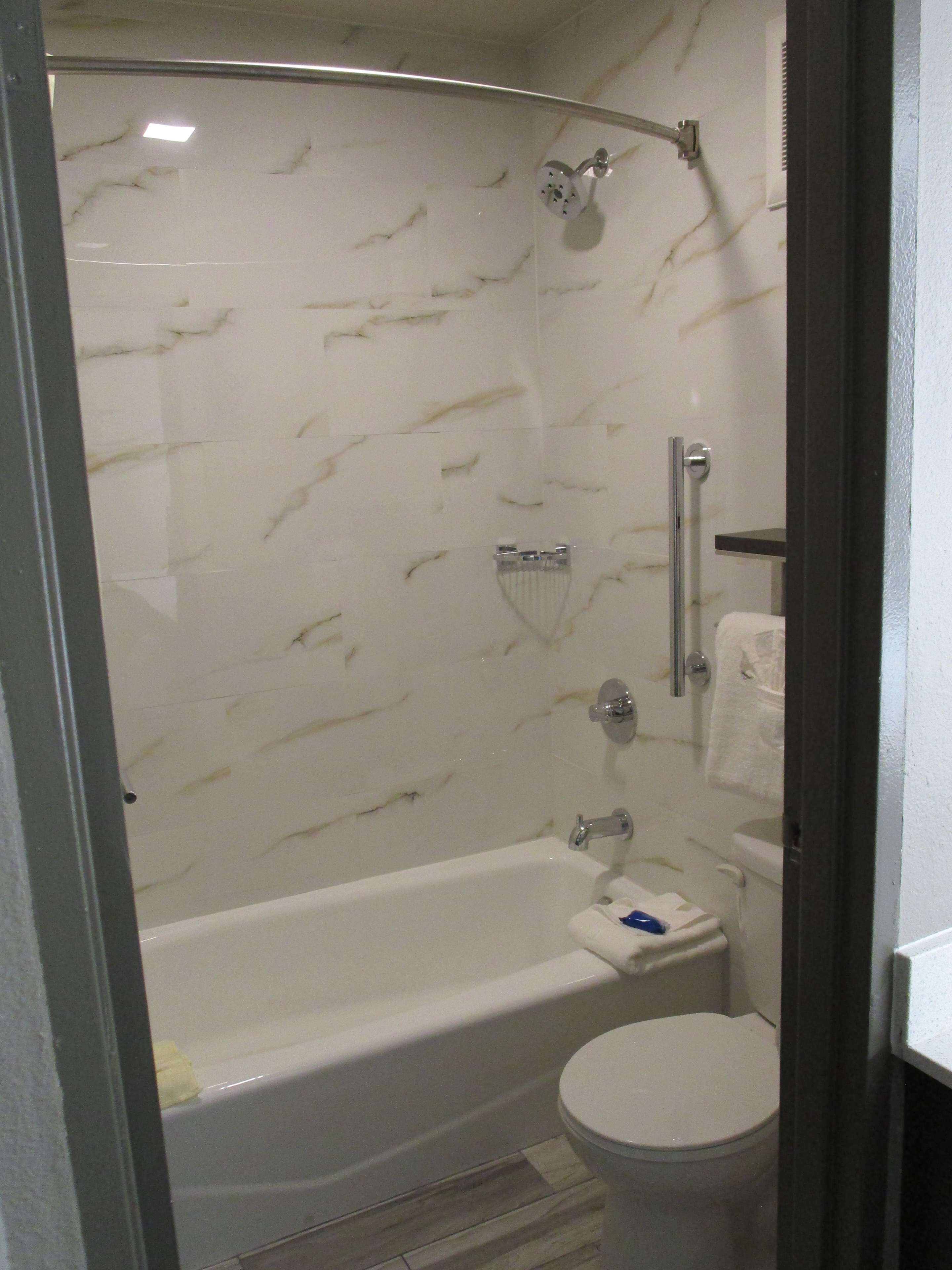 Un baño con ducha de mampara, bañera y retrete.
