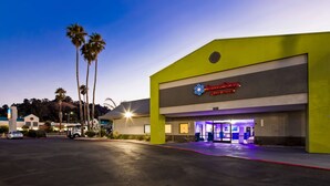 A hotel with a modern design, a prominent sign for SureStay Plus Hotel, and a parking lot with a few cars. - SureStay Plus Hotel by Best Western Point Richmond (Richmond)
