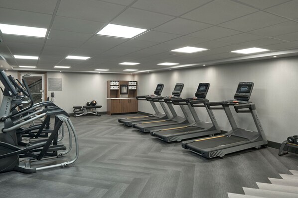 A gym with treadmills, elliptical machines, and weight equipment.