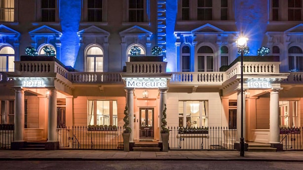 Ein Hotelgebäude bei Nacht mit blauer Beleuchtung.