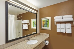 Enjoy a refreshing bathroom experience with a large mirror, sink, and towel rack.