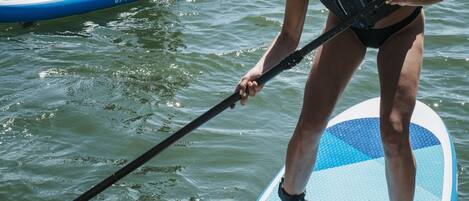 Three people on paddleboards in a calm body of water.