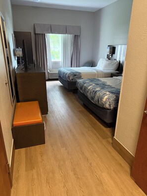 Ein Hotelzimmer mit einem Bett, einem Schreibtisch, einem Stuhl und einer kleinen Sitzecke.