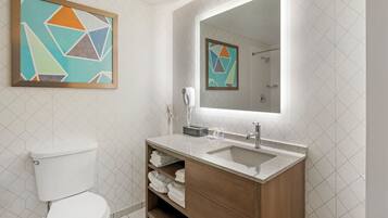 Une salle de bain moderne avec des toilettes, un meuble-lavabo et un grand miroir.