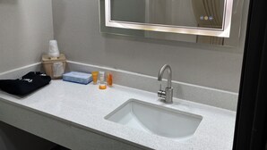 Een badkamer met een wastafel, spiegel en handdoekhouder.