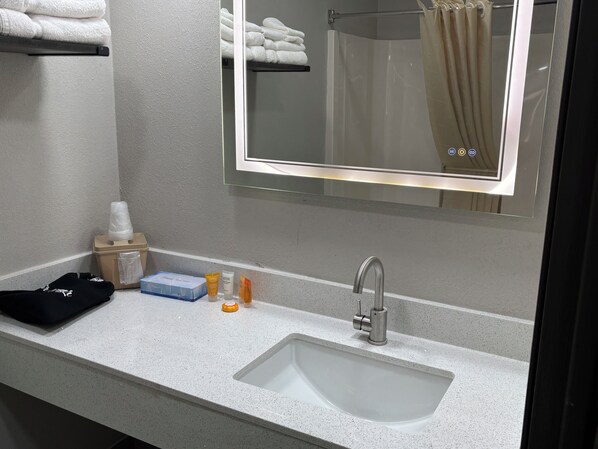 A bathroom with a sink, mirror, and towel rack.