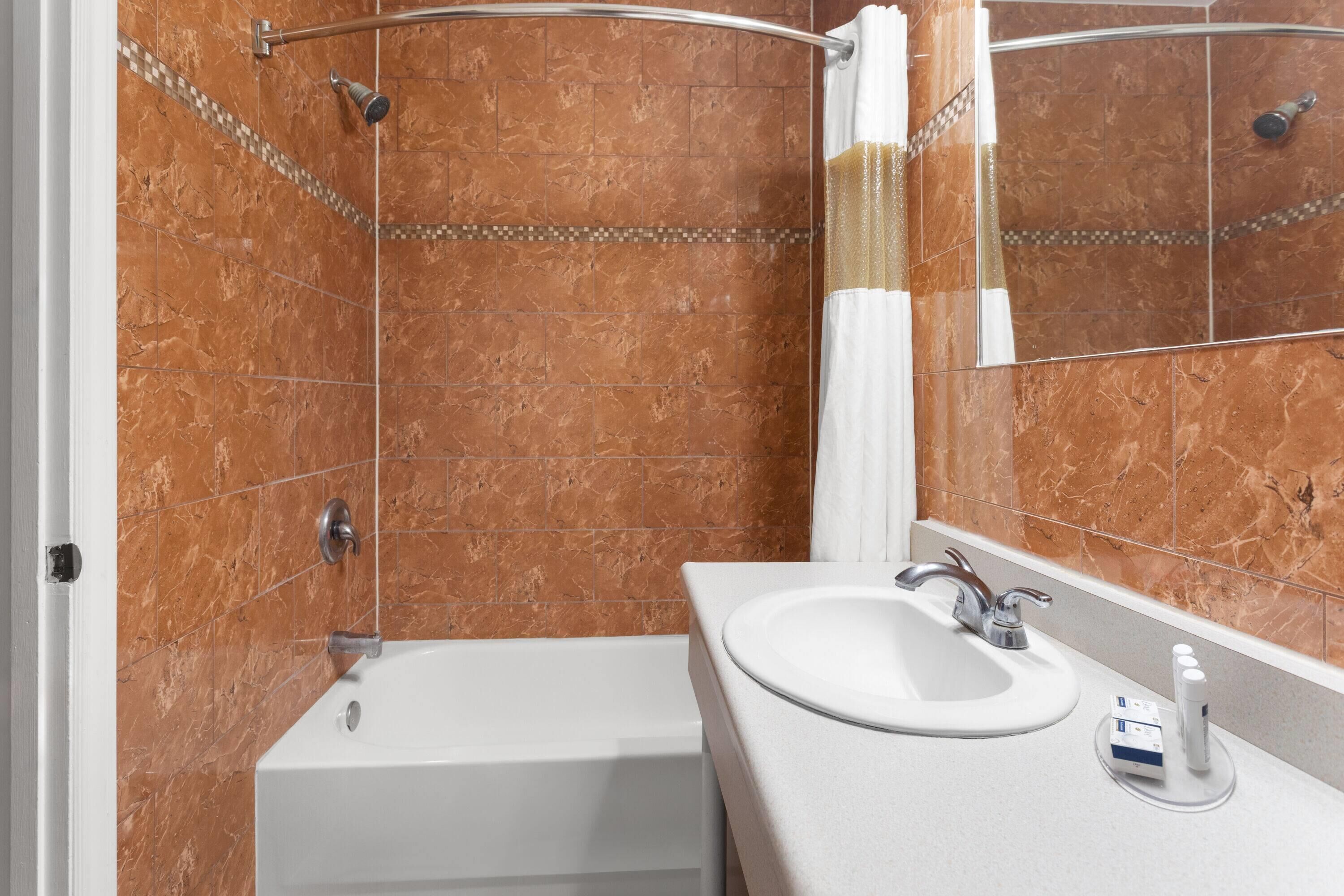 A bathroom with a bathtub, a sink, and a shower.