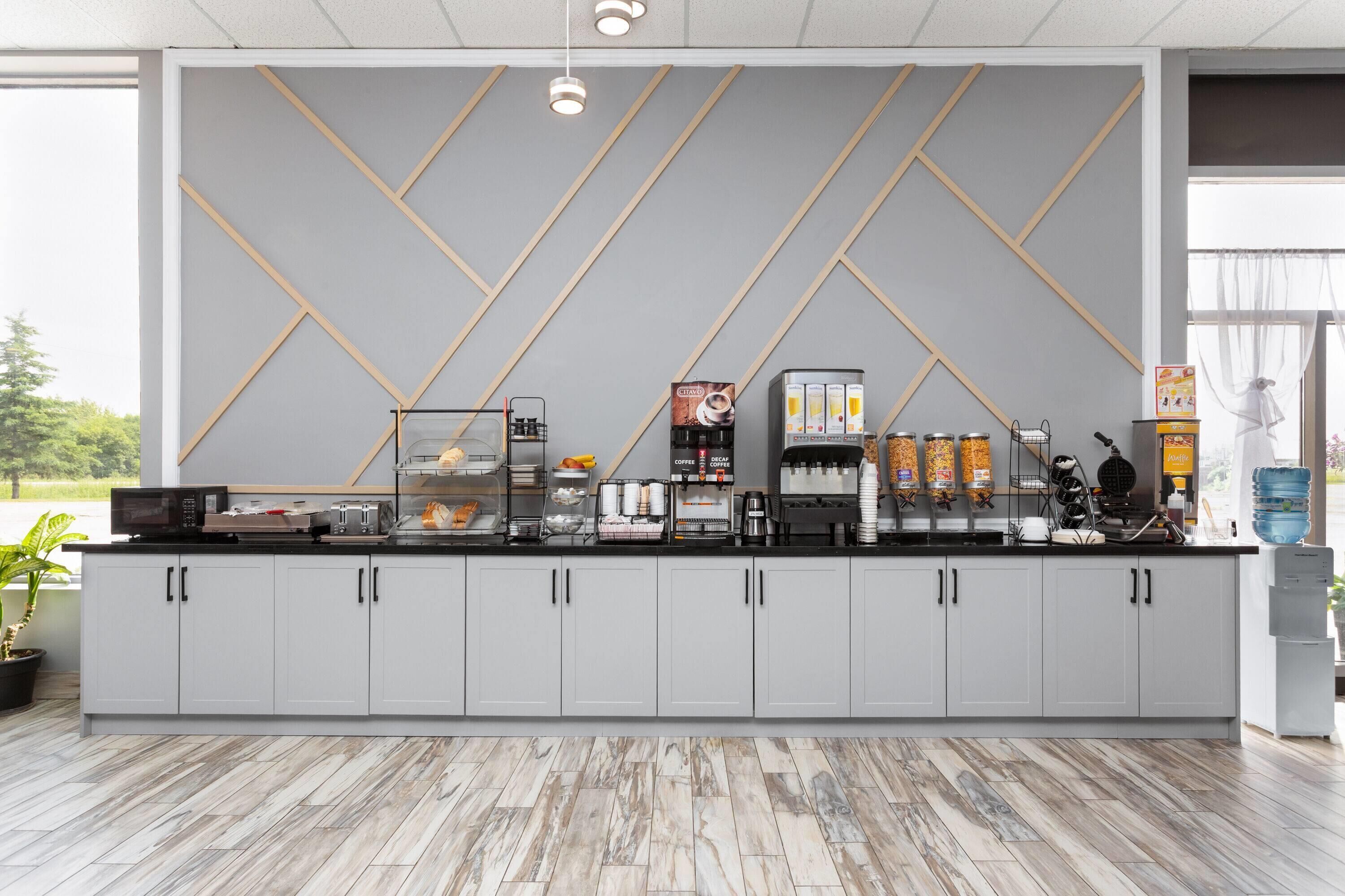 Un'area cucina moderna con un bancone, macchine da caffè e pensili.