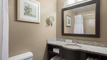 A bathroom with a sink, mirror, towel rack, and toilet.