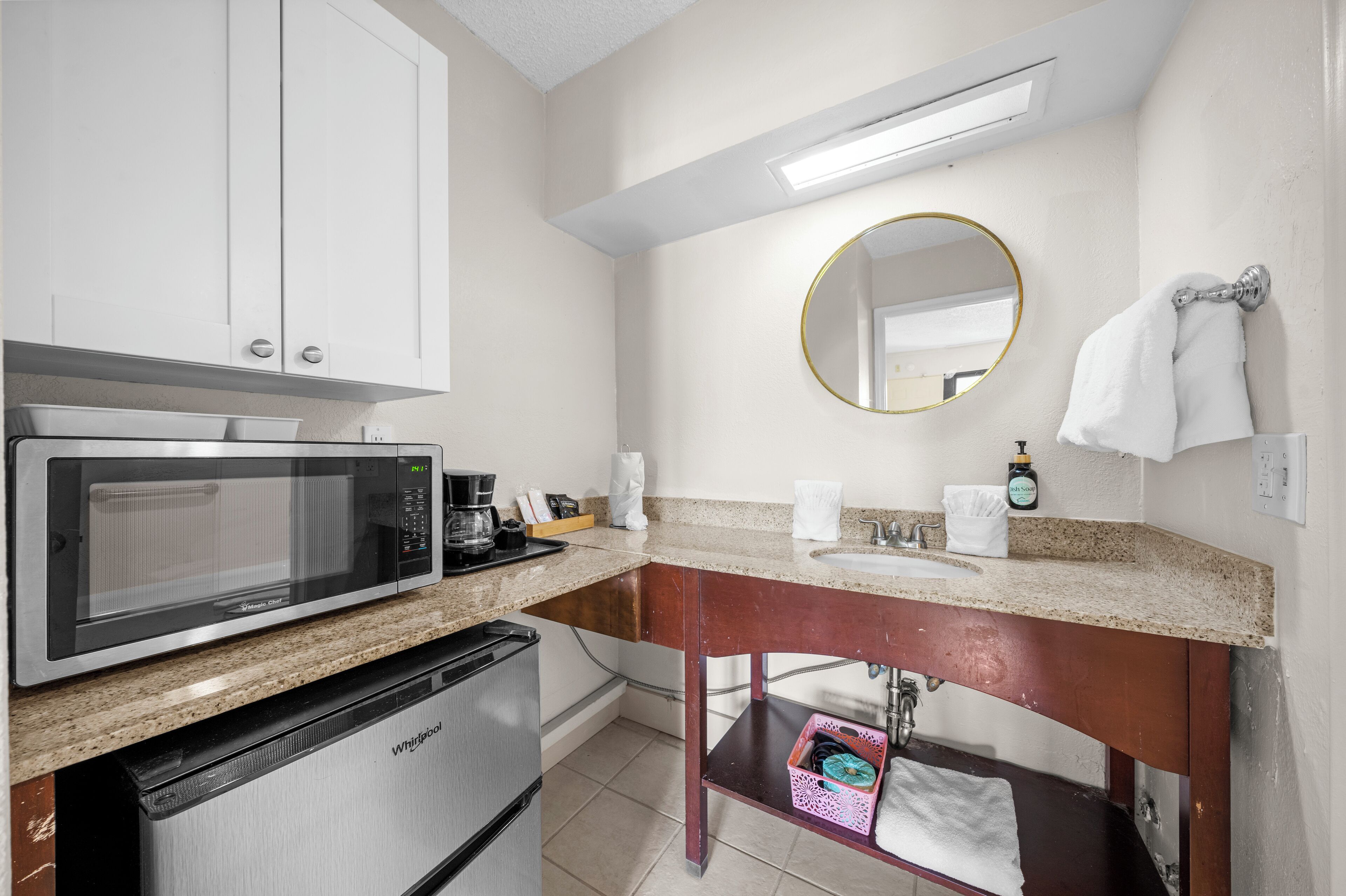 A compact kitchenette with a microwave, coffee maker, and a small refrigerator.