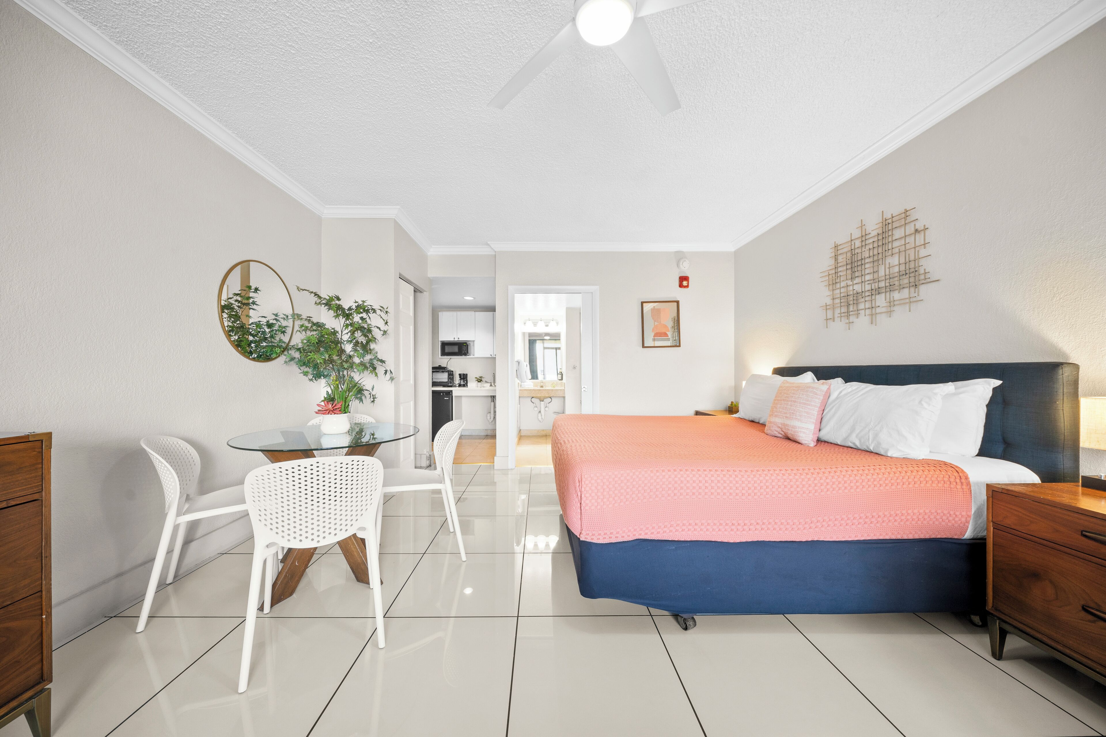 A modern bedroom with a bed, bedside table, and a small desk with a chair.