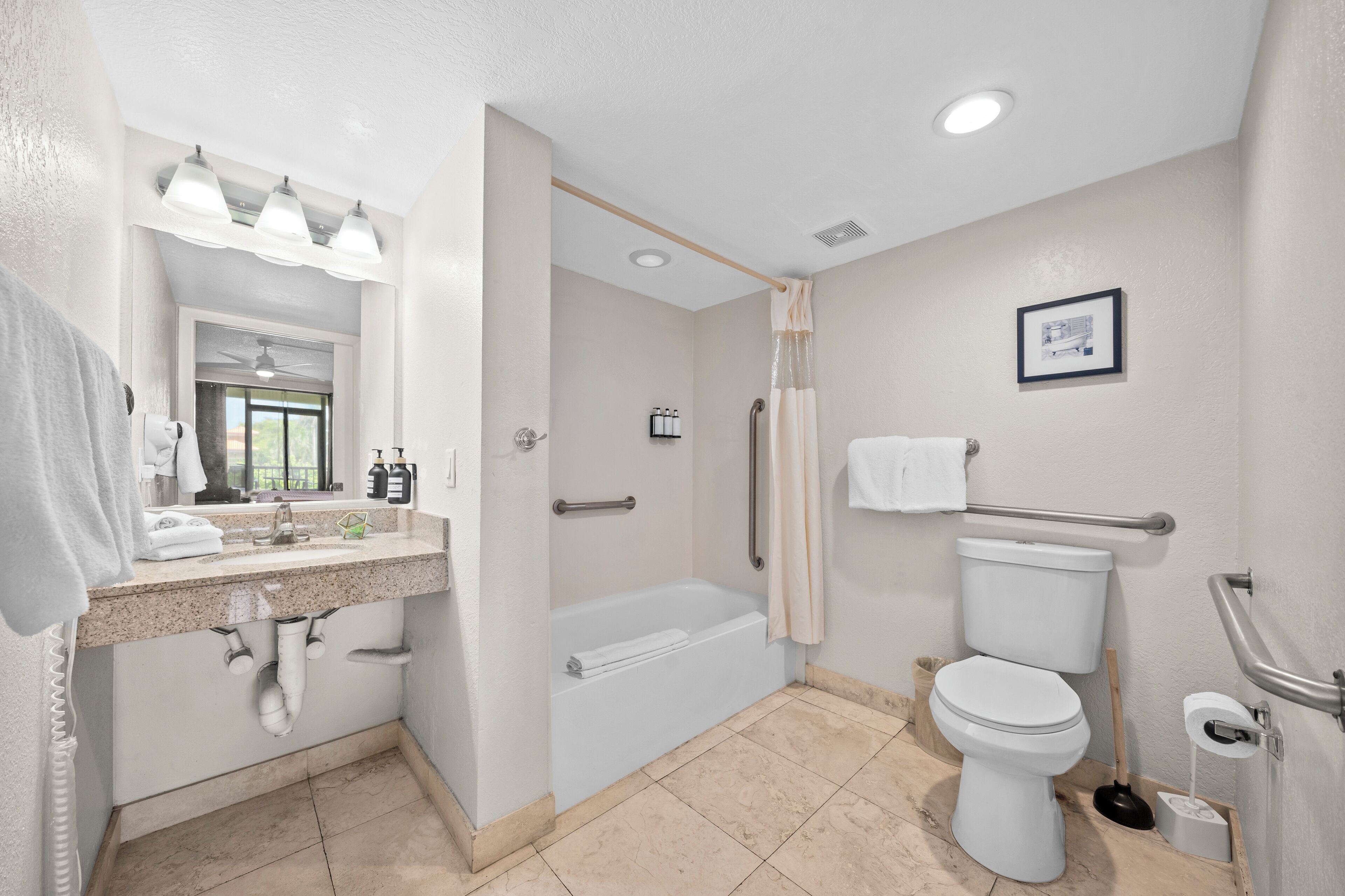 Un baño moderno con lavamanos, espejo, tocador, bañera, inodoro y ducha.