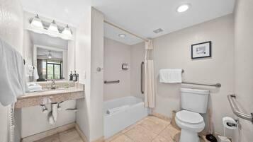 Un baño moderno con lavamanos, espejo, tocador, bañera, inodoro y ducha.