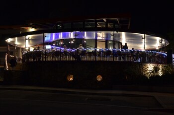 Enjoy waterfront dining with a semi-circular outdoor seating area and a curved roof supported by columns. at Sea Club Resort