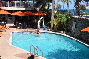 Piscine extérieure, parasols de plage, chaises longues