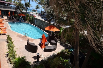 Relax by the pool surrounded by lush tropical plants and palm trees. at Sea Club Resort