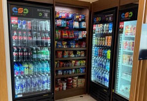 Una zona de conveniencia con dispensadores de bebidas y estantes de aperitivos.