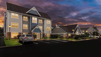 A multi-story hotel with a parking lot and well-maintained landscaping.