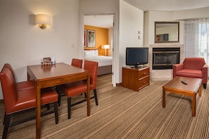 A hotel room with a dining table, chairs, a TV, a fireplace, and a sofa. - Sonesta ES Suites Charleston (Charleston)