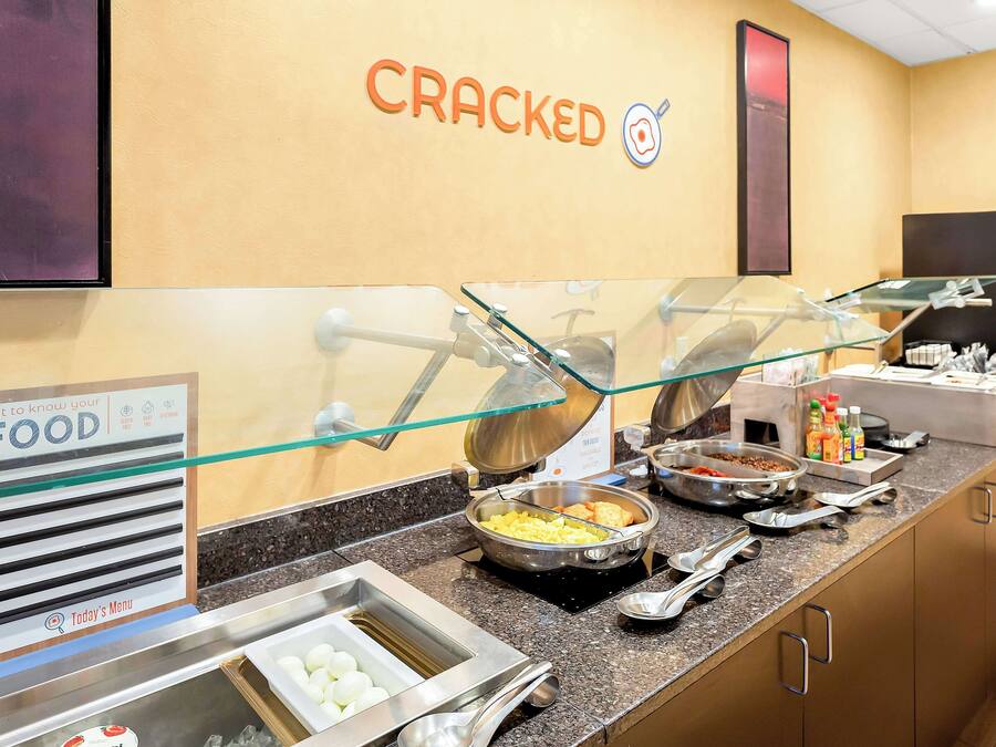 Een buffetgedeelte met diverse eetstations, een bord waarop het menu van vandaag staat aangegeven en een muur met de naam 'CRACKED'.