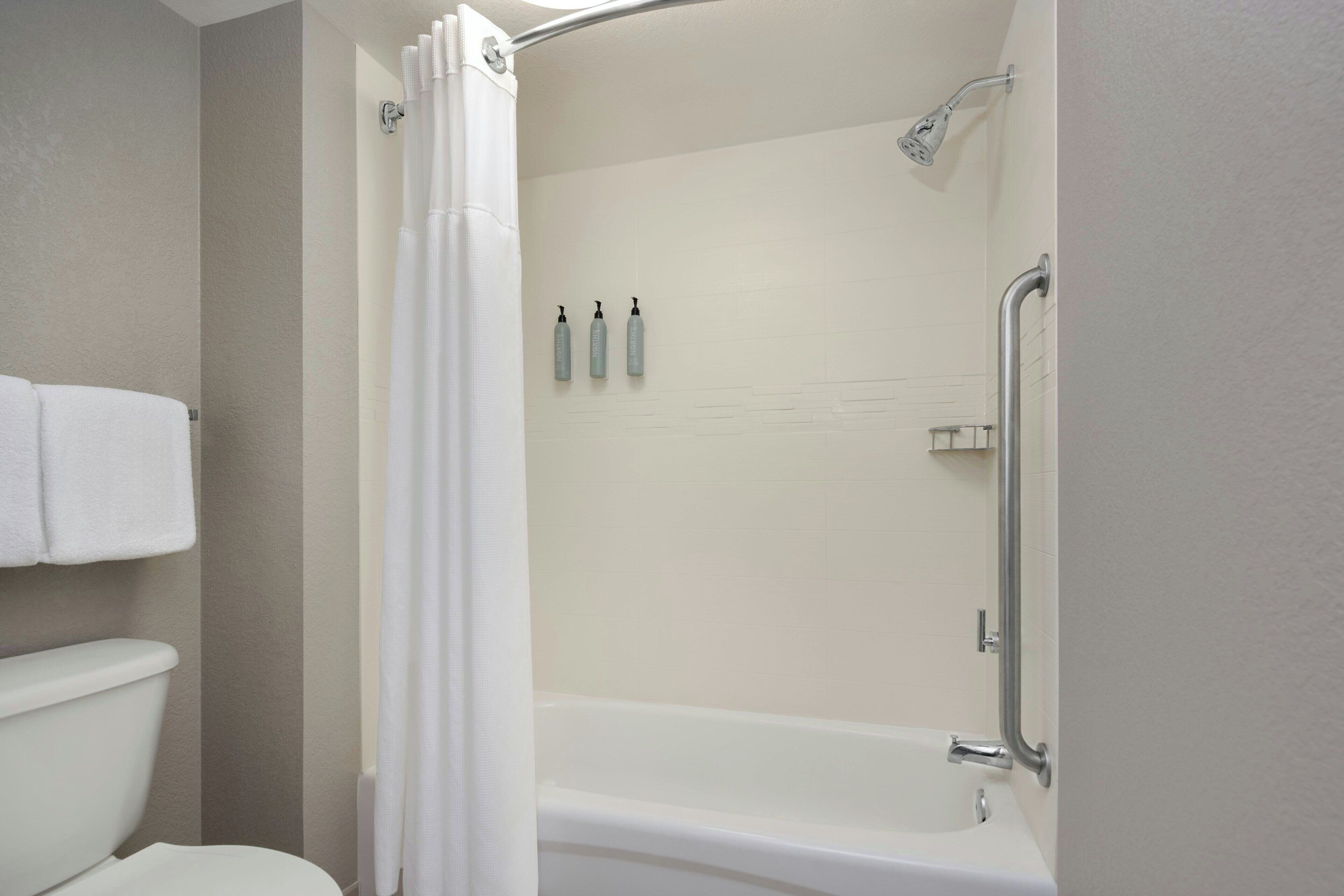 Ein Badezimmer mit Dusche, Toilette und Handtuchhalter.