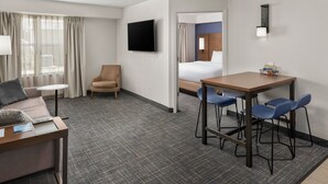 A hotel room with a bed, a desk with chairs, a TV, and a window with curtains. - Residence Inn by Marriott Orlando East/UCF Area (Orlando)