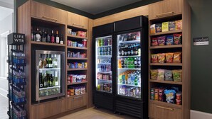 A section of a hotel with wooden cabinetry, a refrigerated beverage display, and snack shelves. - Residence Inn By Marriott Raleigh Crabtree (Raleigh)