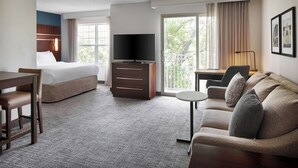 A hotel room with a bed, a TV, a sofa, a desk, and a chair. - Residence Inn By Marriott Raleigh Crabtree (Raleigh)