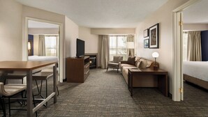 A hotel room with a bed, a sofa, a desk, a TV, and a fireplace. - Residence Inn by Marriott Scranton (Scranton)